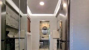 A modern kitchen with stainless steel appliances, a central island, and a view into the dining area. - D A Luxury Suite Jacuzzi (Malevizi)