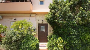 Un bâtiment avec une porte marron, une petite fenêtre et un balcon.