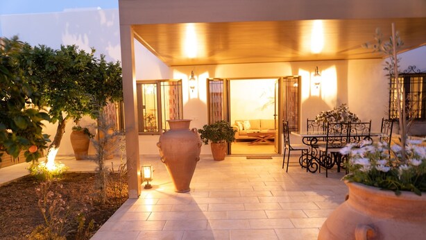 A patio area with large terracotta pots, a dining table with chairs, and a sofa. - Cretan Rhapsody Villa With Private Yard (Faistos)