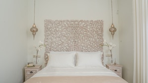 A bed with a decorative headboard, two bedside tables, and hanging lamps. - Cretan Rhapsody Villa With Private Yard (Faistos)