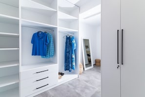 A walk-in closet with open shelves, a mirror, and a wardrobe with a door. - Kyma Luxury Villa With Private Pool (Faistos)