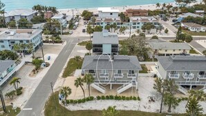 A coastal residential area with beachfront properties, a road, and a beach in the background. - Sunrays Anchor by Duncan Real Estate (Holmes Beach)