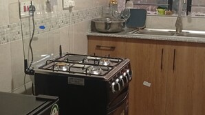 Una cocina con estufa a gas, horno y refrigerador.