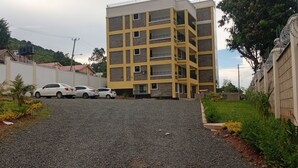 Un edificio de varios pisos con un estacionamiento al frente.