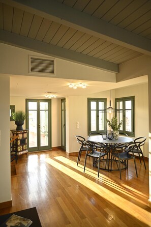 A dining area with a round table, chairs, and a potted plant.