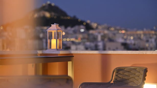 A balcony with a chair and a lantern, overlooking a cityscape at dusk. - Ma Maison N°10 Elegant Plaka Villa under Acropolis (Athens)