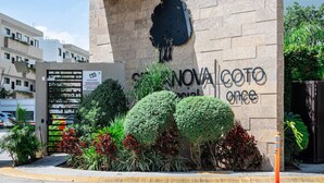 L’entrée d’un immeuble, avec une enseigne indiquant « Hôtel NOVA COTO ».