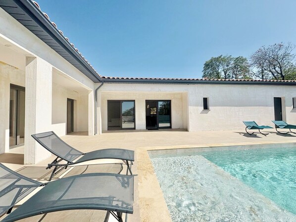 A modern poolside area with lounge chairs, a clear pool, and a building with a tiled roof. - Villa with private pool, not overlooked, near Carcassonne - 4 bedrooms (Barbaira)
