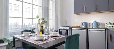 A modern kitchen with grey cabinets, a built-in oven, and a dishwasher.