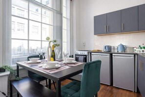 A modern kitchen with grey cabinets, a built-in oven, and a dishwasher. - Winter Sale! Newcastle's Most Central Apartment (Newcastle upon Tyne)