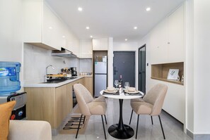 Een moderne keuken met een eettafel, stoelen, een waterdispenser en een koelkast.