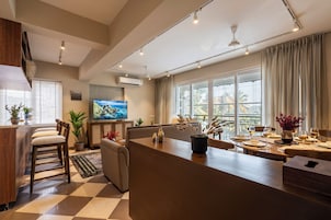 Una cocina moderna con comedor, ventanas amplias y un televisor de pantalla plana.