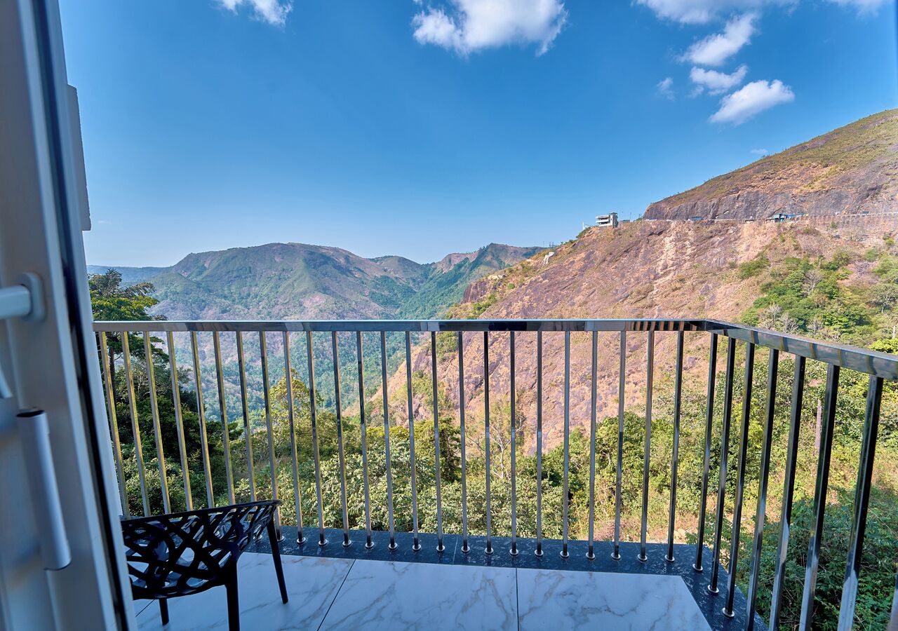 Un balcon doté d’une rambarde en métal, d’où l’on peut admirer un paysage montagneux.