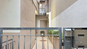 A narrow corridor with a metal gate, a mail slot, and a potted plant. - Cà 4 Nevodi Chiara by Ca-Sa Check (Chioggia)