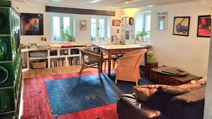 A cozy living room with a sofa, a dining table, and a kitchen area. - Holiday Home 'Charming' with Shared Terrace and Wi-Fi (Neckargemünd)