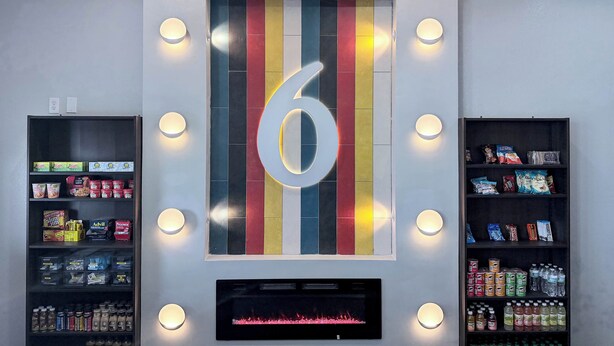 A wall with a large number '6' and shelves stocked with snacks and beverages. - Studio 6 Suites Lexington, Kentucky (Lexington)