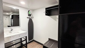 A bathroom with a marble sink, a mirror, a towel rack, and a black shower enclosure. - Studio 6 Suites Lexington, Kentucky (Lexington)