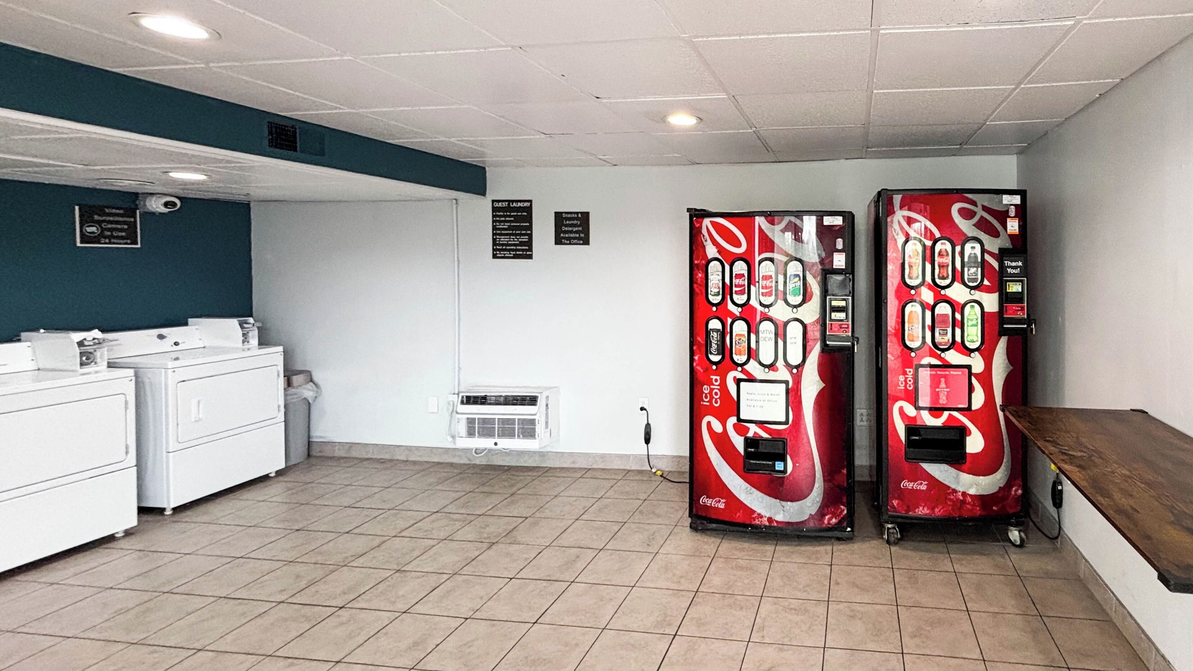 Un espace buanderie équipé de deux distributeurs automatiques, d’un lave-linge et d’un sèche-linge.
