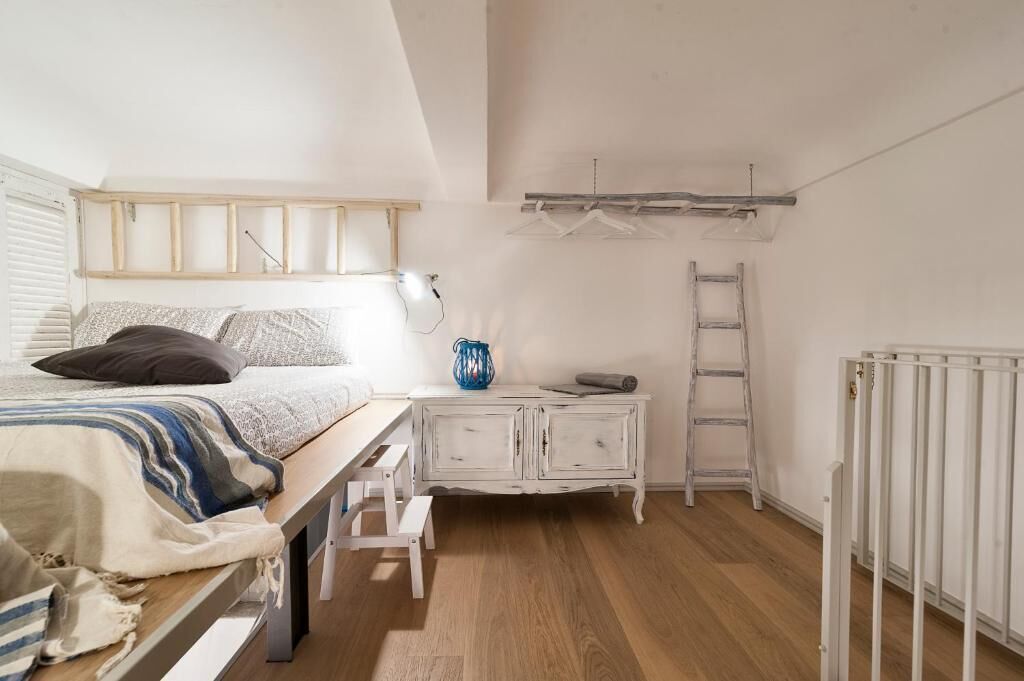 Une chambre à coucher avec un lit, une commode, une échelle et un radiateur.