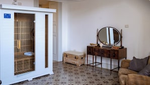 Une pièce comprenant une armoire, une commode en bois, un miroir et un sol à motifs.