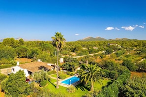 A residential property with a swimming pool, surrounded by lush greenery and a mountainous backdrop. - Country Home "Can Moreno" with Pool, A/C, Wi-Fi, Garden & Terrace (Illes Balears)