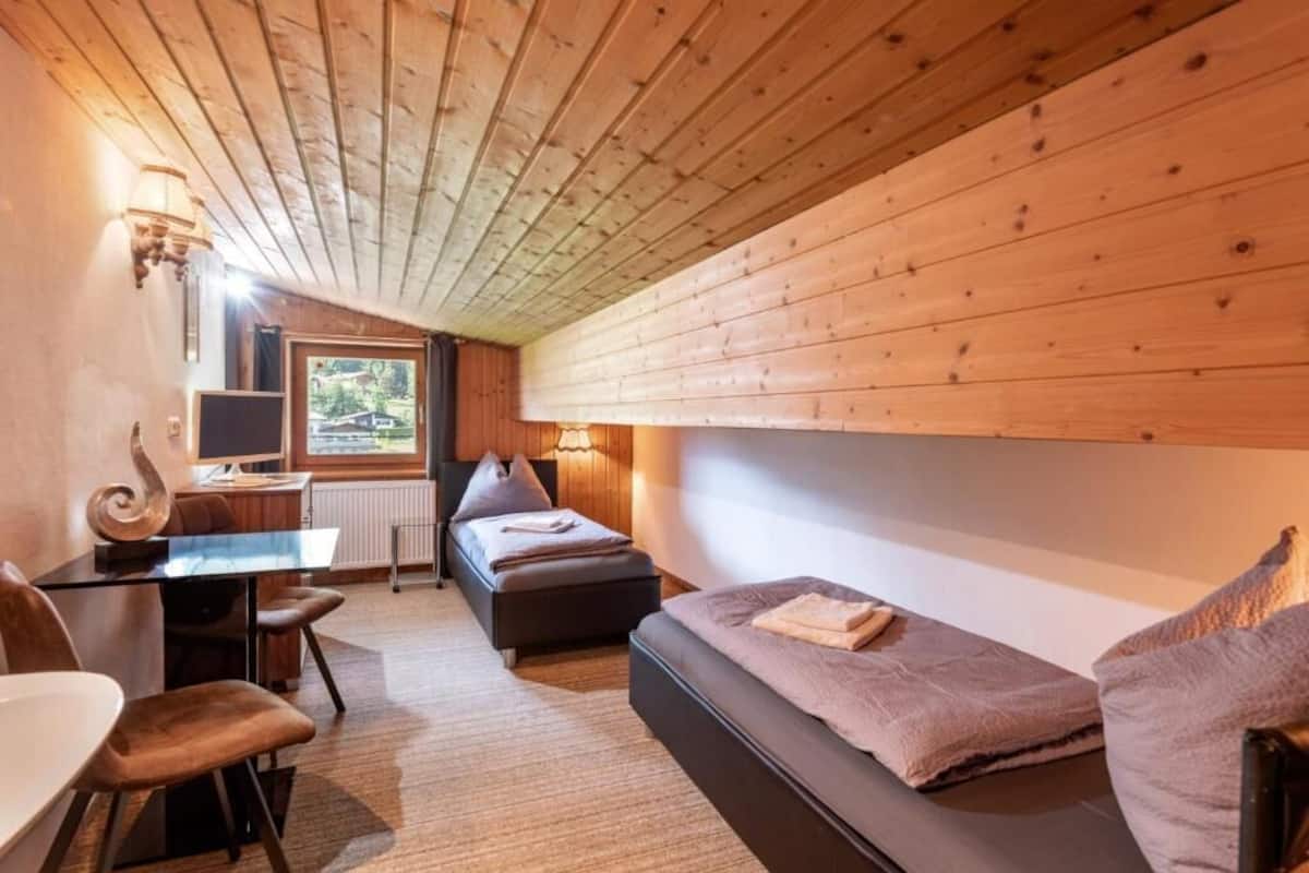 Ein gemütliches Zimmer mit einem Bett, einem Schreibtisch und einem Stuhl.