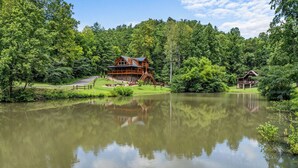 Eine am See gelegene Lodge mit einer großen Terrasse, einer überdachten Veranda und Blick auf den umliegenden Wald.