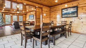 A wooden interior with a dining table, chairs, a sofa, and a Christmas tree. - Spacious*Private Pool*Home Theater*Close to Pigeon Forge (PIGEON FORGE)