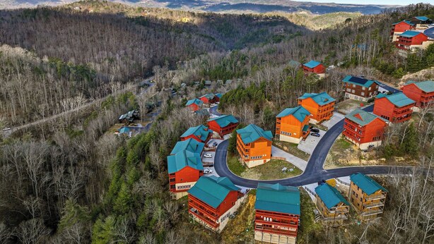 A resort with multiple buildings, a winding road, and a forested valley with mountains in the background. - Spacious*Private Pool*Home Theater*Close to Pigeon Forge (PIGEON FORGE)