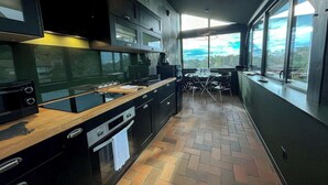 Een moderne keuken met een groot raam, een eethoek en uitzicht op de omgeving.