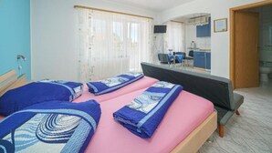 A hotel room with two beds, a desk, a chair, a TV, and a bathroom. - Apartments Milka Vodice (Vodice)