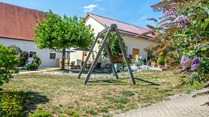 A residential area with a house, a swing set, and a garden.