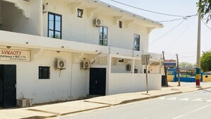 A building with a sign for 'SANGACITY' offering rooms, WiFi, and TV. - Hôtel SangaCity Bakel  (Bakel)