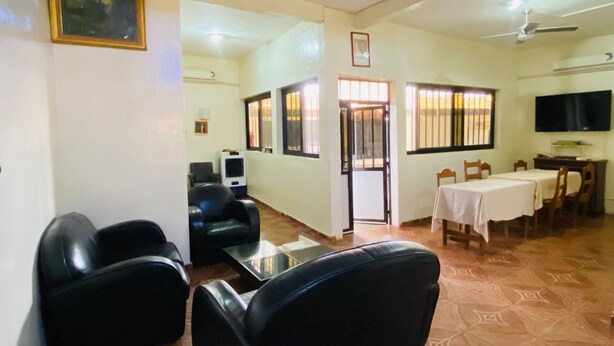 A living room with a sofa, a coffee table, a TV, and a dining area with a table and chairs. - Hôtel SangaCity Bakel  (Bakel)