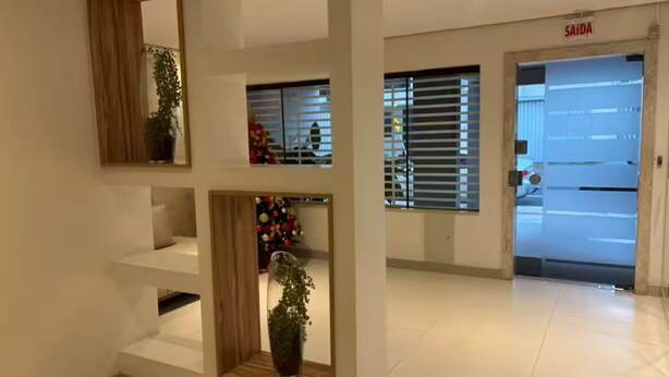 En hotellobby med en receptionsdisk, en skylt med texten ”SAÍDA” och en julgran.
