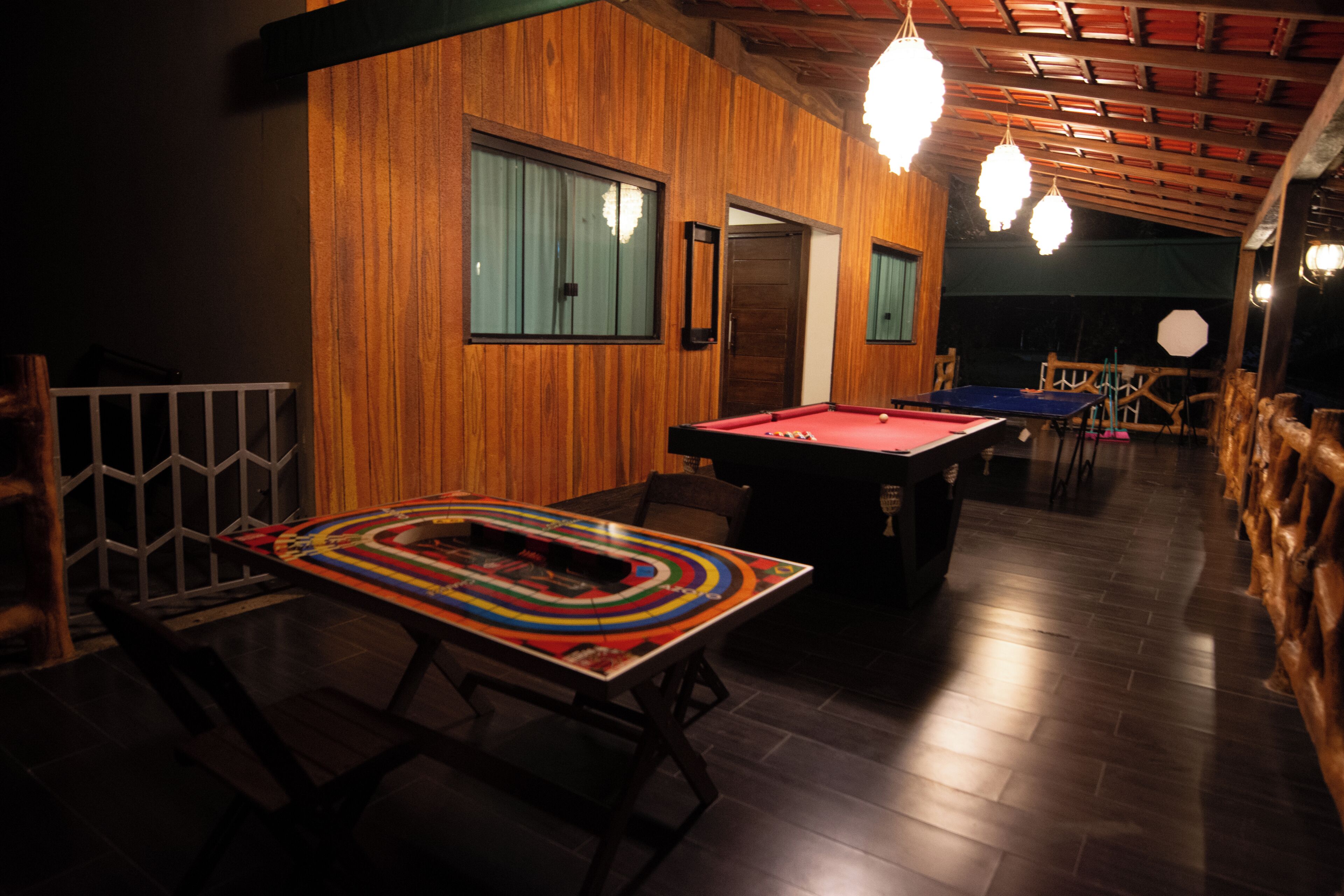 A billiards table in a dimly lit room with wooden walls and a sloped ceiling.