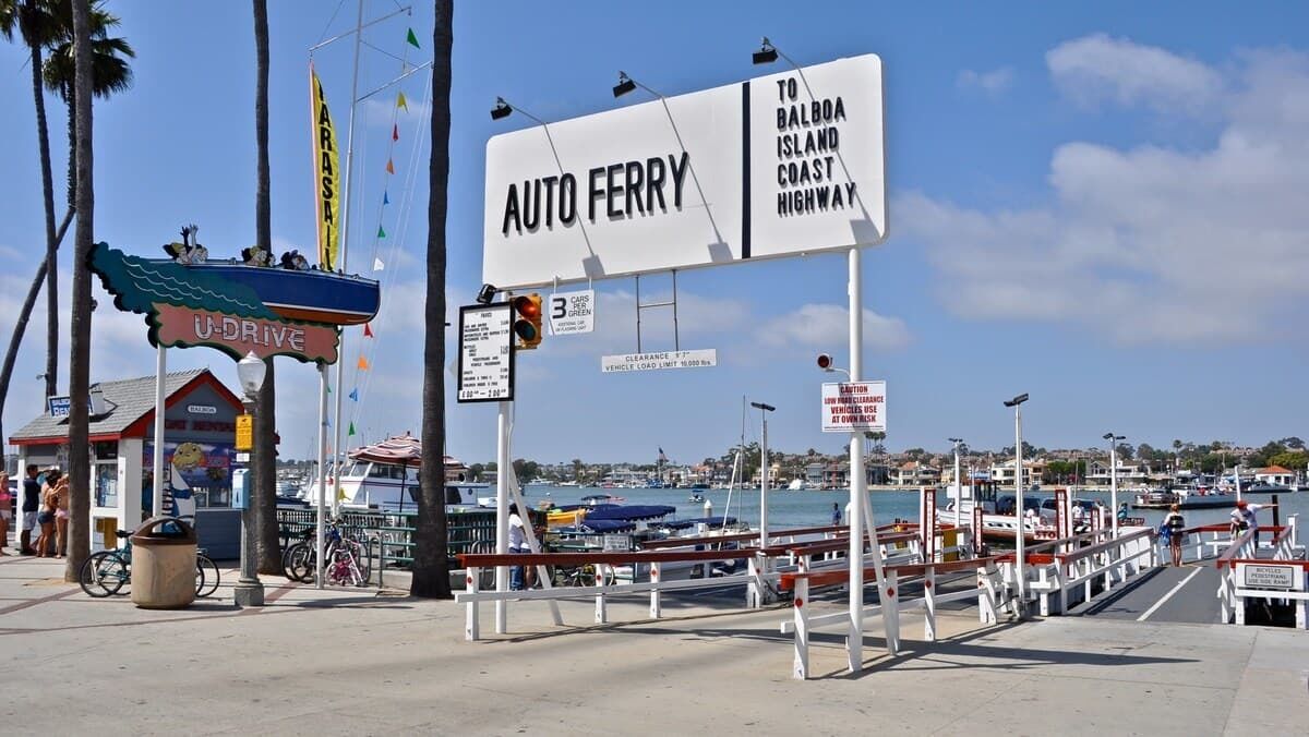 A U-Drive service area with a ferry sign, a marina, and boats in the background.