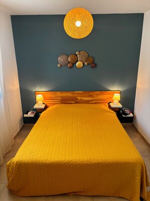 Ein Schlafzimmer mit einem großen Bett, zwei Nachttischlampen, einer Wandleuchte und dekorativer Wandgestaltung.