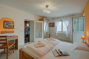 Un dormitorio con cama, mesita de noche y escritorio con silla.
