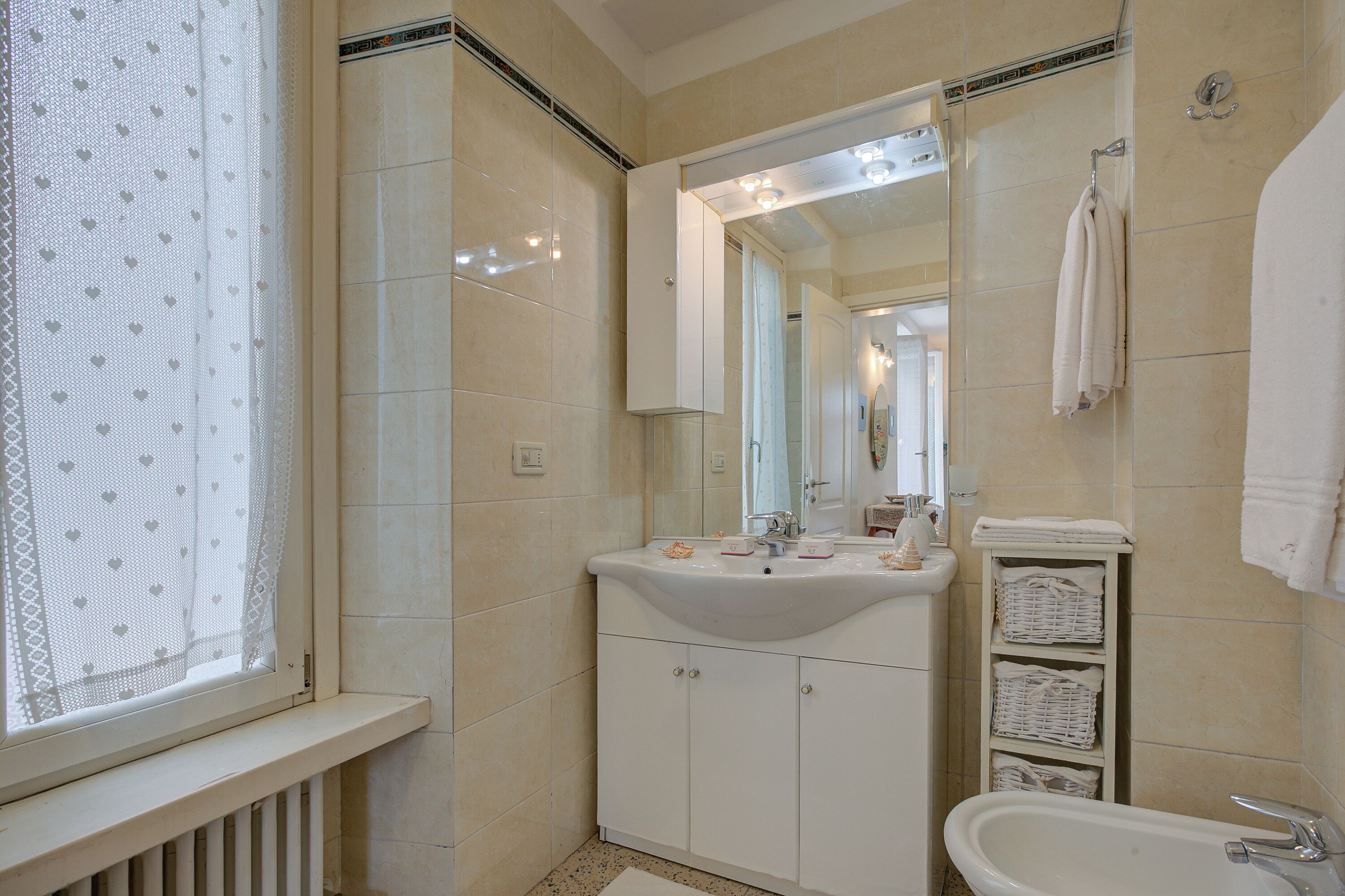Ein Badezimmer mit Waschbecken, Spiegel und Handtuchhalter.