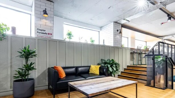 Een modern interieur met een leren bank, een houten bijzettafeltje en potplanten.