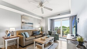 Ein modernes Wohnzimmer mit Sofa, Couchtisch und Blick ins Freie.