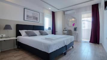 Habitación de hotel moderna con una cama grande, mesitas de noche, un escritorio y un espejo de baño.