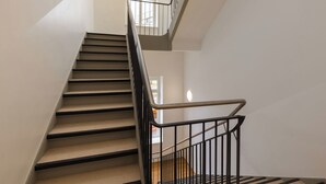 Uma escada moderna com corrimão de metal, que leva a um segundo andar.