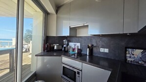 A modern kitchen with a large window, built-in appliances, and a view of the outdoors. - Panoramic view and terrace in Biarritz (Biarritz)