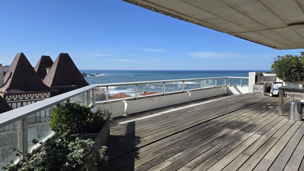 A wooden deck with a view of the ocean and coastal buildings. - Panoramic view and terrace in Biarritz (Biarritz)