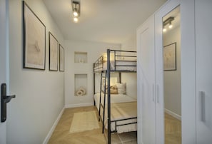 A bunk bed room with a door, framed artwork on the walls, and a light fixture. - Panoramic sea view in Cannes (Cannes)