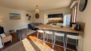 Eine moderne Küche mit Bar, Esstisch und einer Couch.