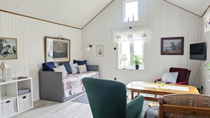 Um quarto aconchegante com cama, mesa, cadeira e televisão.
