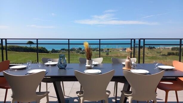A dining table set for four with a view of the sea and landscape. - Villa Bellevue (Donville-les-Bains)